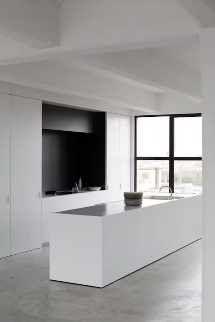 Kitchen and island in the Antwerp loft beside the dining area