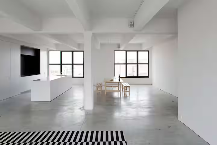 Bright open Antwerp loft room with dining table and windows